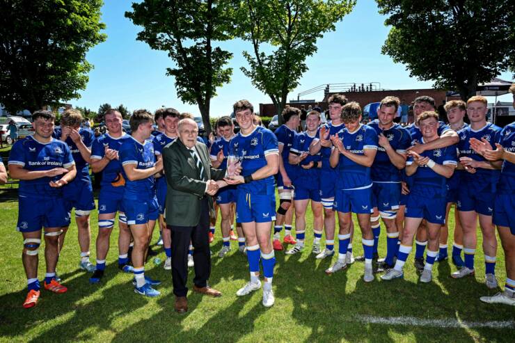 Victorious Leinster 'A' captain Charlie Tector receives the trophy from IRFU Committee member John McKibbin
